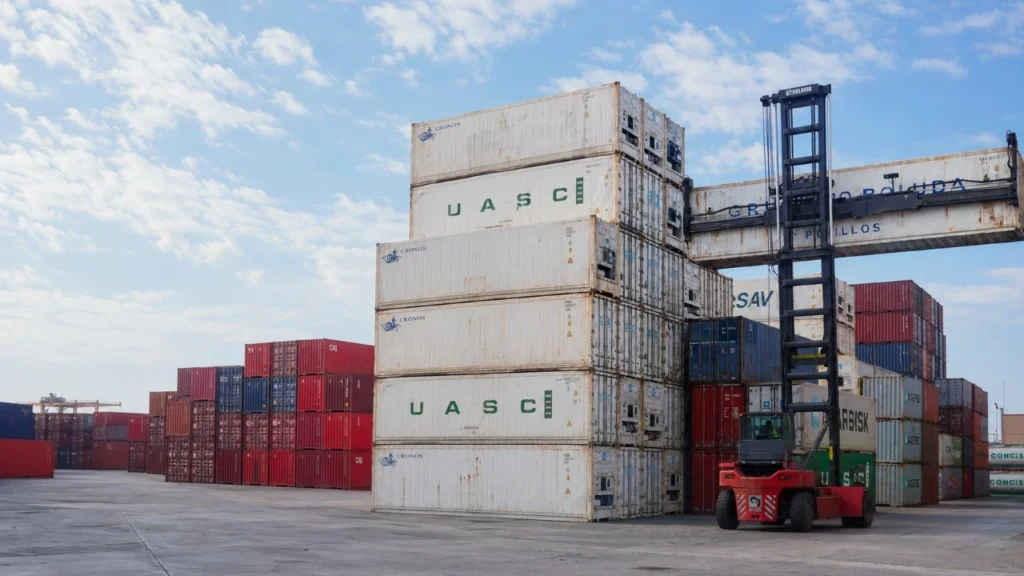 Reefer containers with visible refrigeration units in an operational container depot.