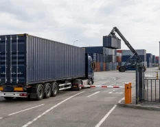 Truck entering a European container depot for container pickup, return or storage operations.