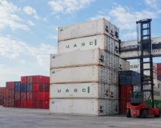 Reefer containers with visible refrigeration units in an operational container depot.