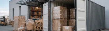 Contenedor para stock estacional con mercancía paletizada junto a una nave logística para ampliar capacidad temporal de almacenaje