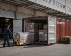 Contenedor de almacenaje temporal SILVERSEA Containers junto a una nave industrial durante una reforma o mudanza, con palés y mercancía en traslado